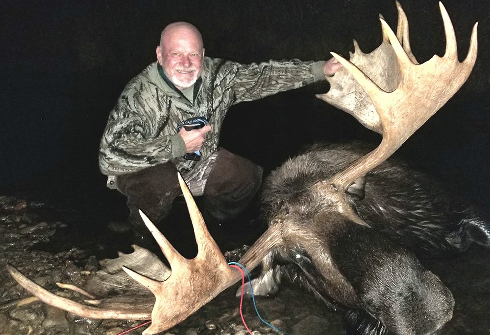 Hunter with bull moose in Alaska