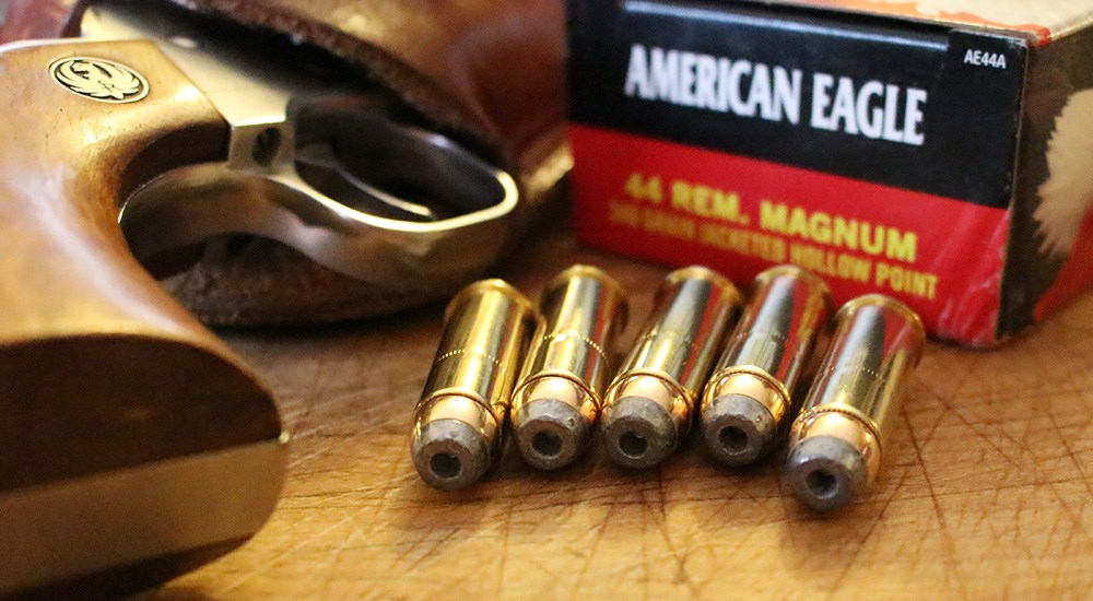 American Eagle .44 Remington Magnum ammunition laying on table next to Ruger revolver.
