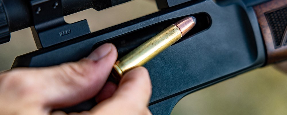 Remington 360 Buckhammer rifle cartridge being loaded into lever action side gate rifle.