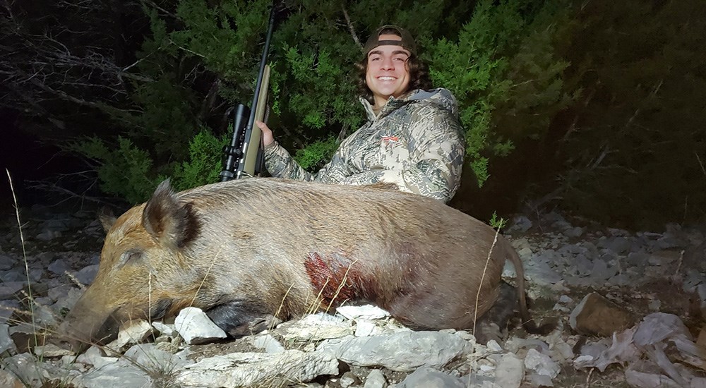 Hunter posing with wild pig in Texas.