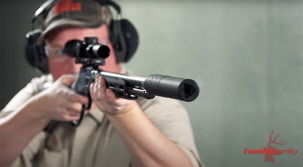 Male shooting lever action rifle with Banish 46-V2 suppressor.