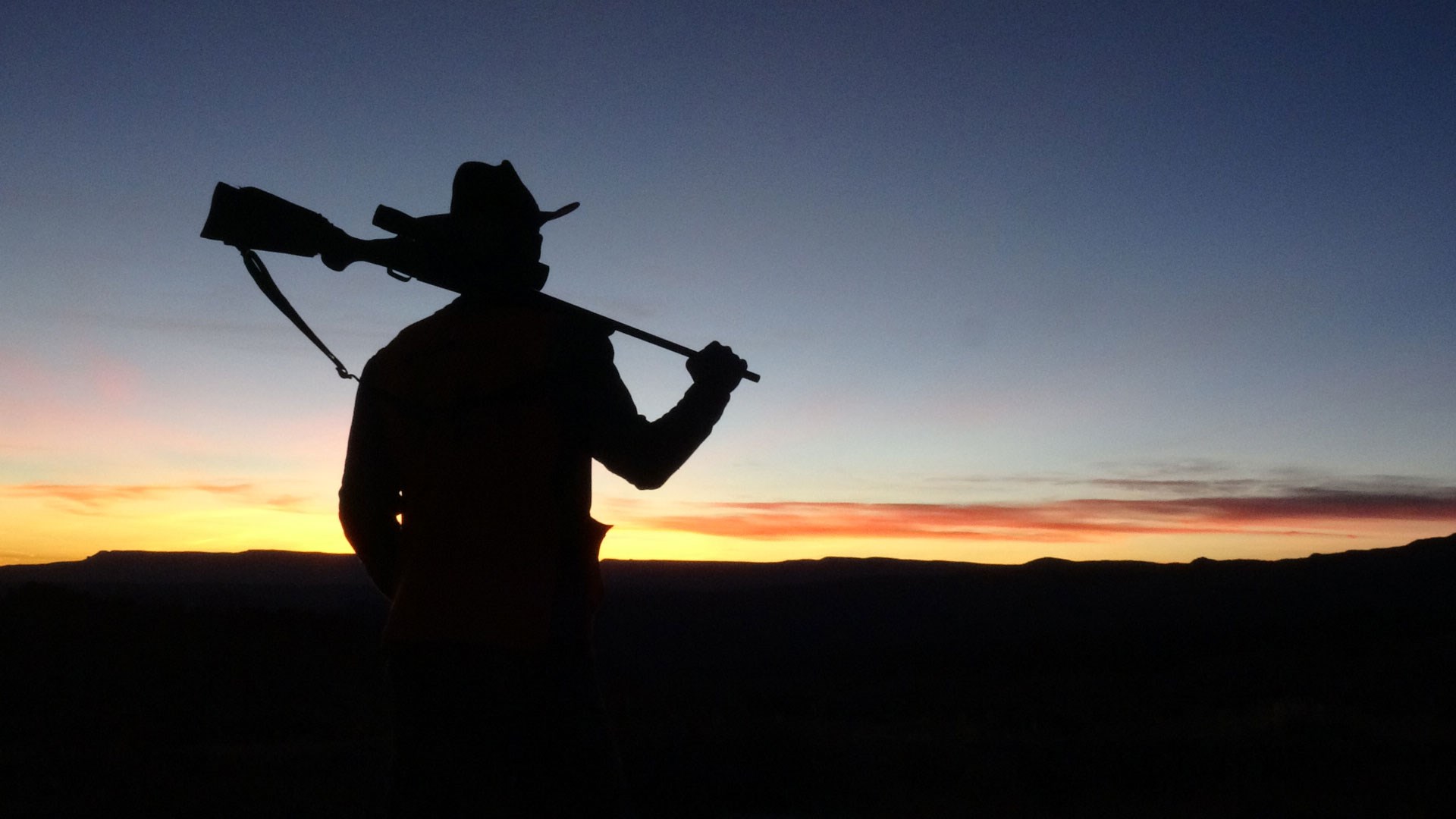 Hunter silhouetted at sunset