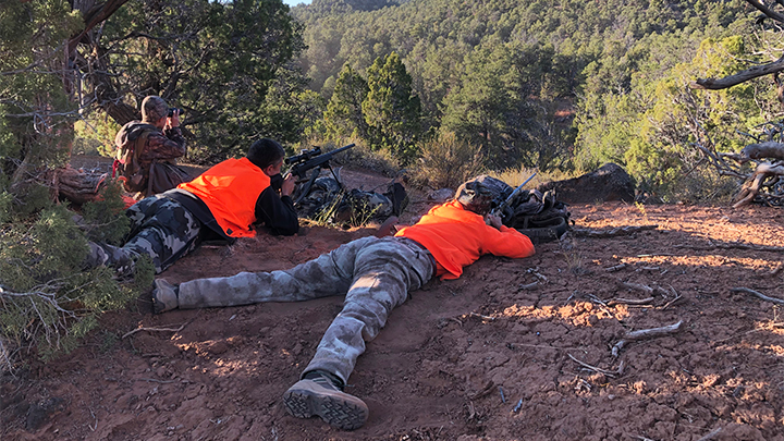 Hunters in prone position preparing to take a shot in the field