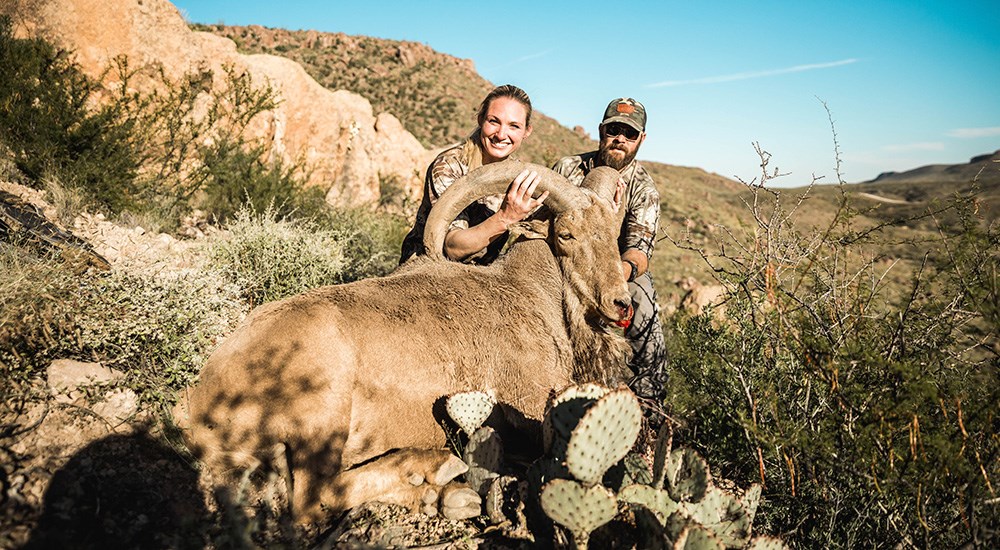 Female hunter posing with West Texas aoudad.