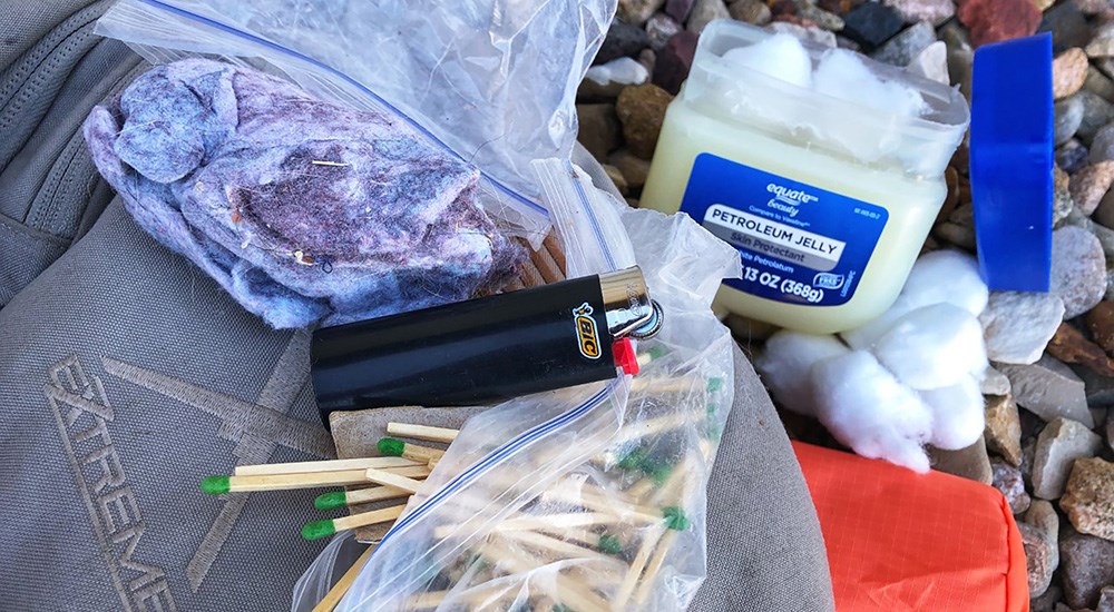 Firestarting sticks next to lighter and petroleum jelly.