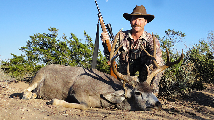 Hunter posing with mule deer taken with 7mm Remington Magnum cartridge