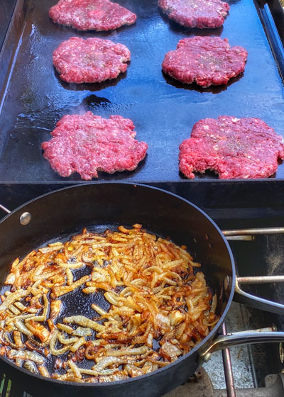 Burgers on the grill, onions in the cast iron