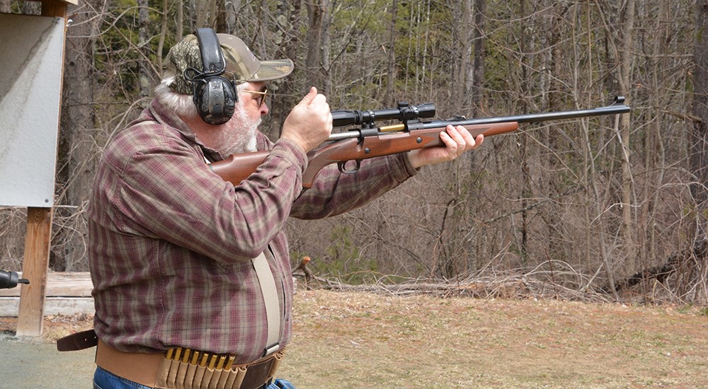 Man shooting bolt action dangerous game rifle at shooting range