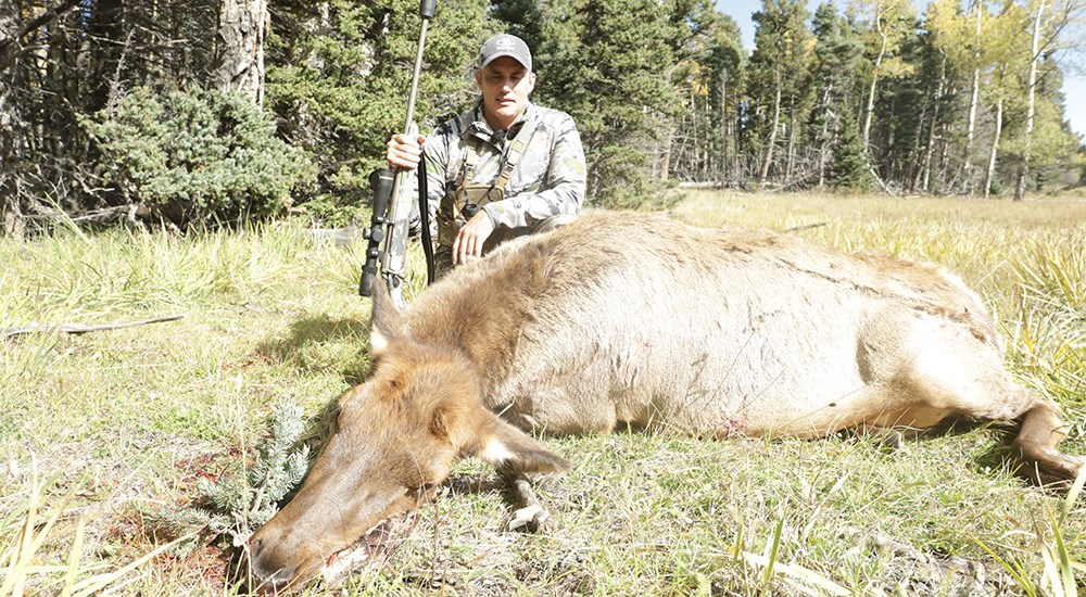Male hunter posing with cow elk.
