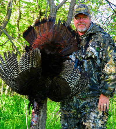 Mike Roux Holds turkey in air