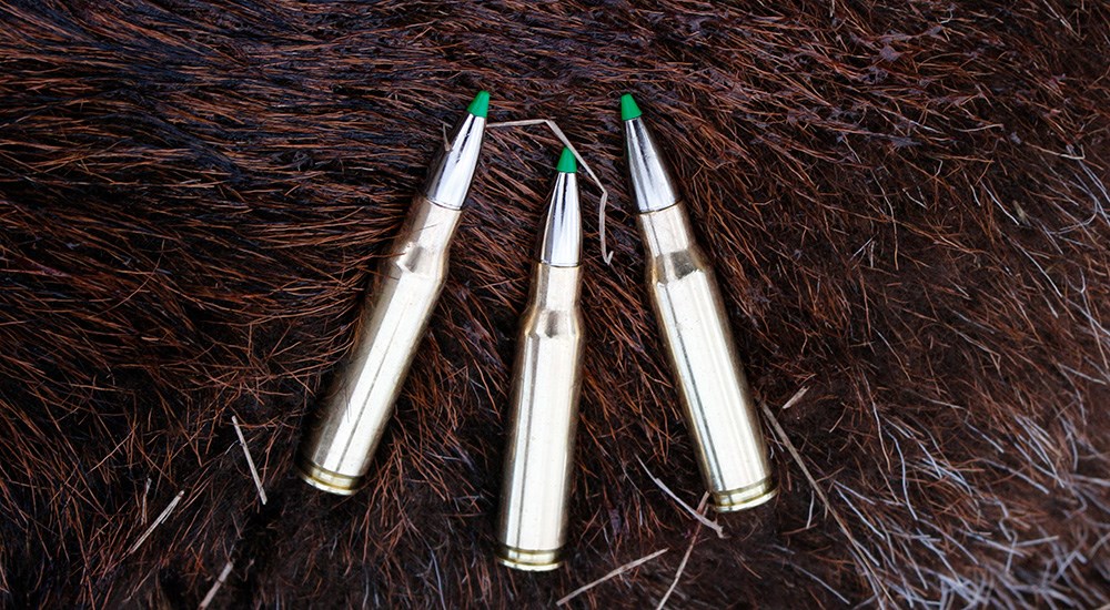 Three cartridges of Norma EcoStrike .308 Winchester ammunition on wild boar hide.