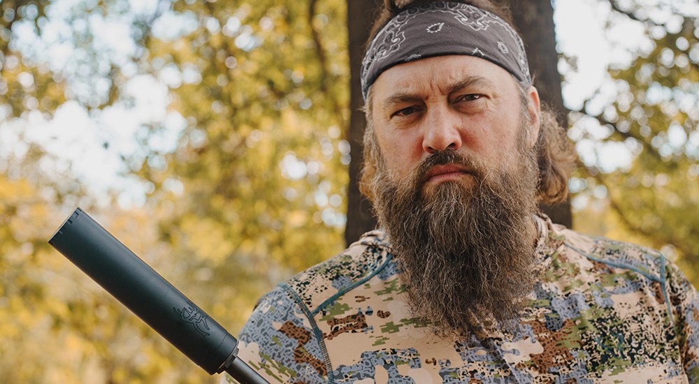 Willie Robertson wearing camouflage holding rifle with Silencer Central Buck 30 suppressor.