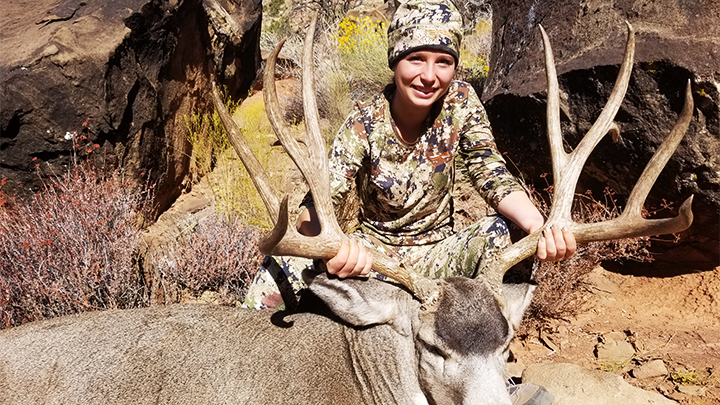 Young hunter with mule deer buck
