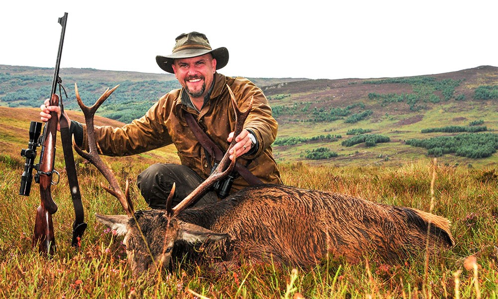 Hunter with Stag holding Rigby Highland Stalker Rifle