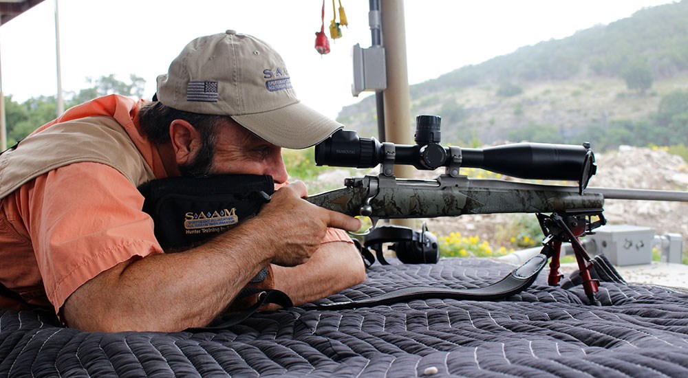 Man shooting bolt-action rifle