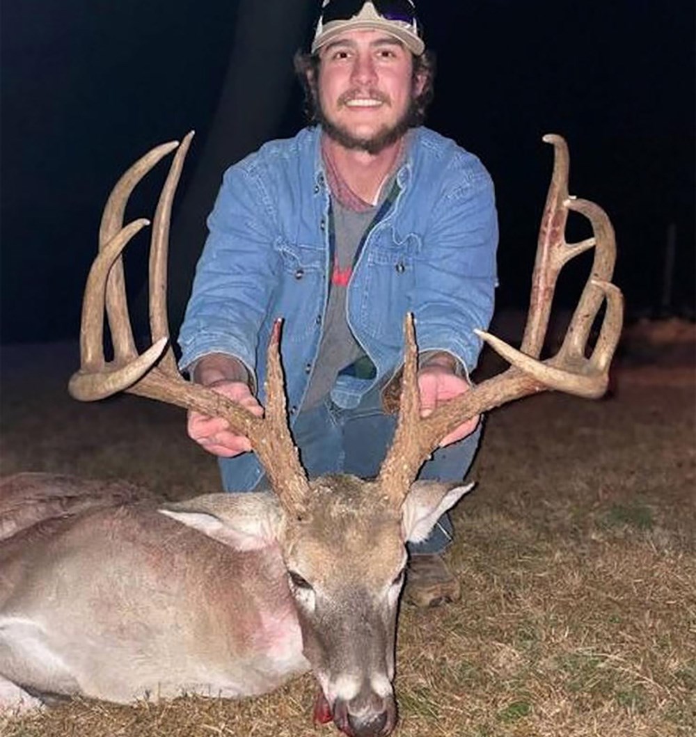 Male hunter in jean shirt holding large whitetail buck killed in Pittsburg County, Oklahoma.