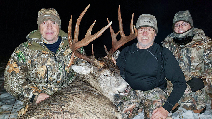 Hunter with two sons after taking 174 7/8 inch 14-point whitetail buck in Alberta, Canada