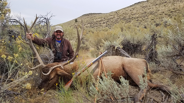 Hunter with bull elk in Idaho