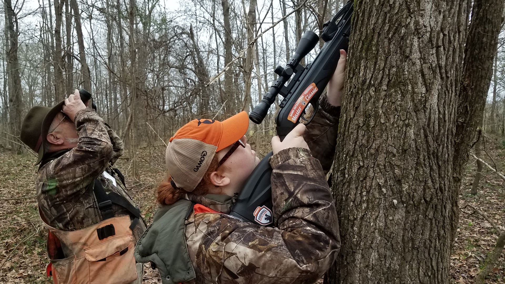 Huntress aims up a tree at a squirrel