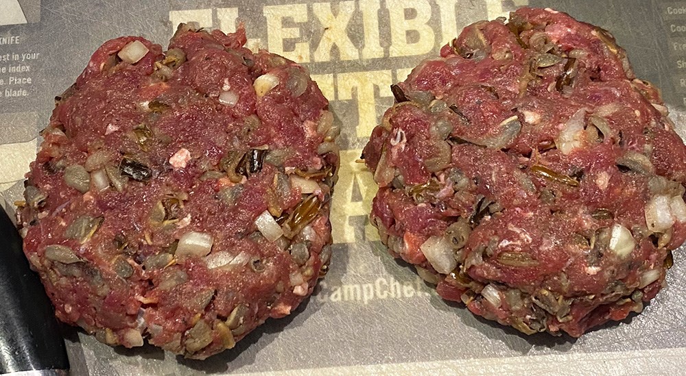 Ground elk mixed with wild rice and onion burger patties before cooking.