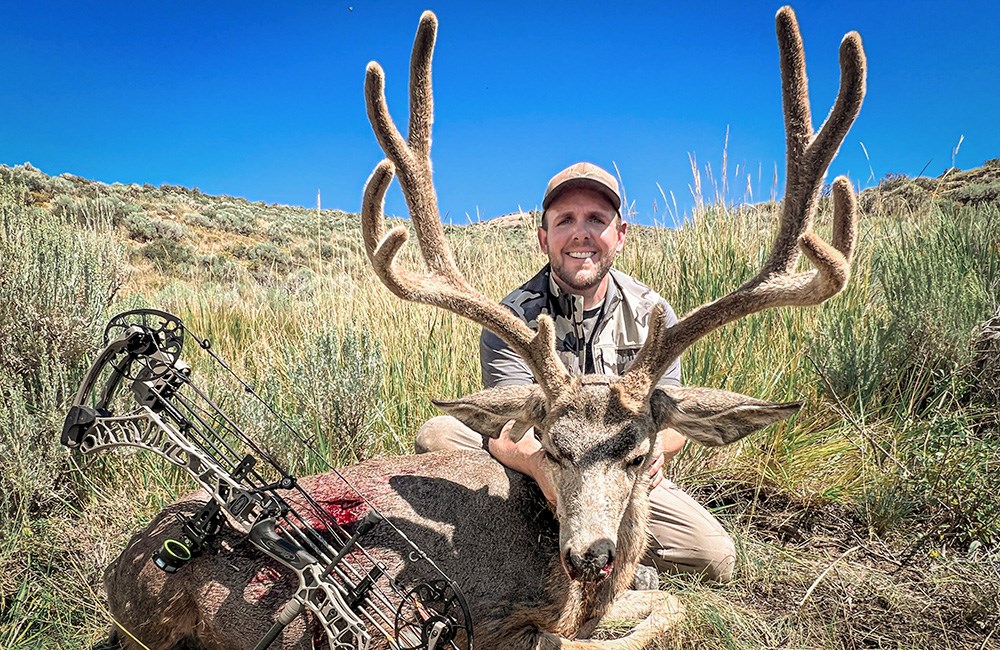 Male hunter with large mule deer buck.