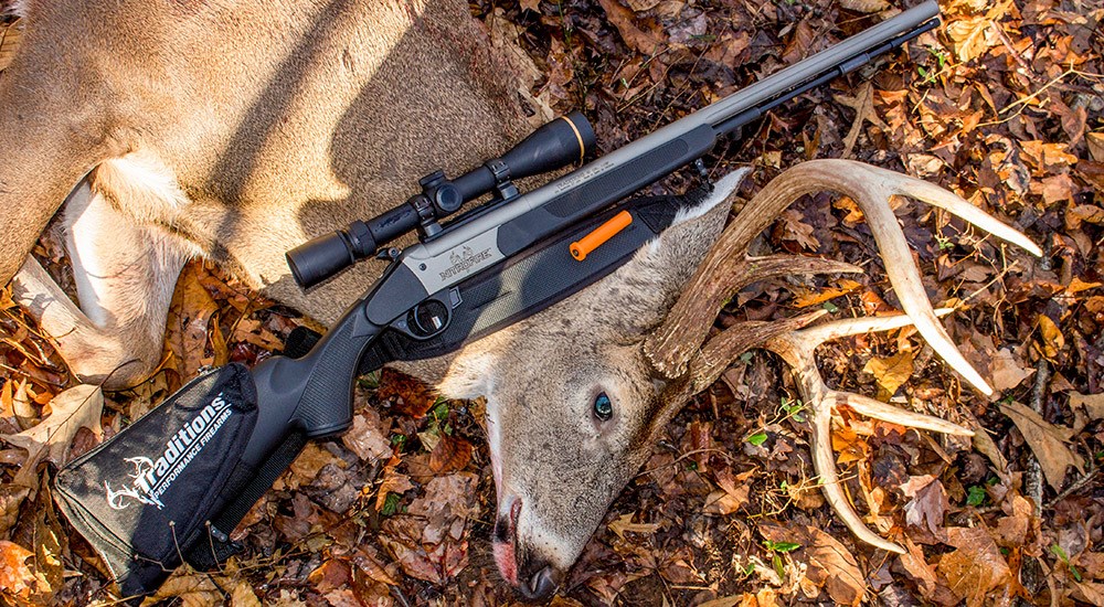 Whitetail buck next to Traditions NitroFire Muzzleloader