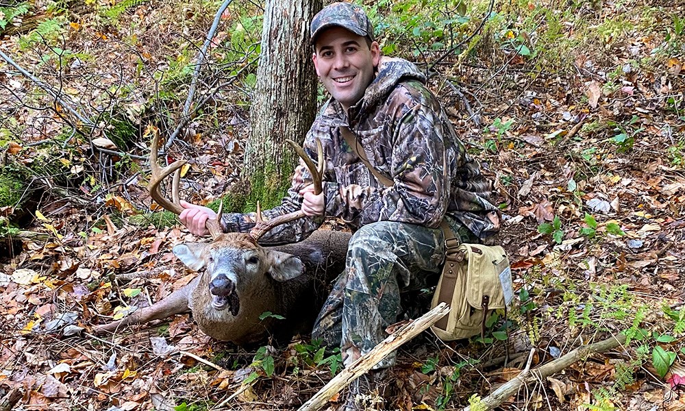 Male hunter with whitetail buck in New Jersey