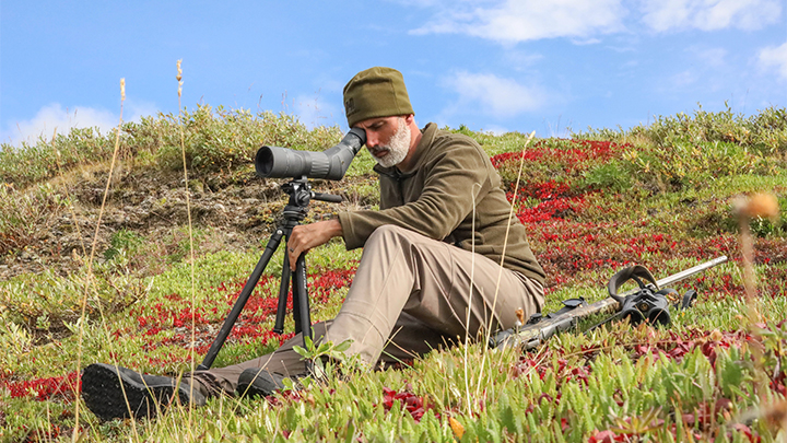 Hunter Using Spotting Scope to Search the Alaska Terrain for Caribou