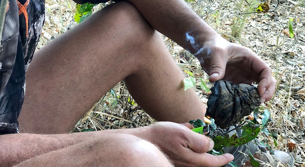 Hunter in Mozambique Lighting Game Feces on Fire to Cover Scent