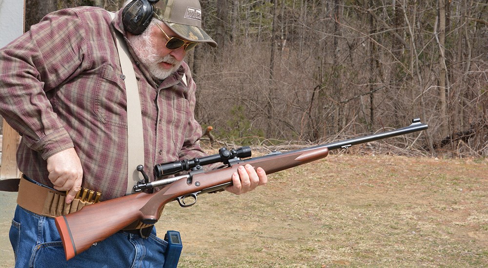 Male hunter practicing drawing ammunition from Galco leather belt to load in rifle