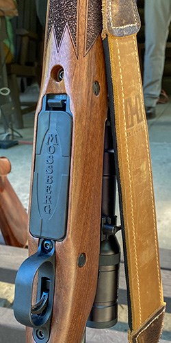 Mossberg Patriot rifle leaning against rack showing detachable magazine at bottom.
