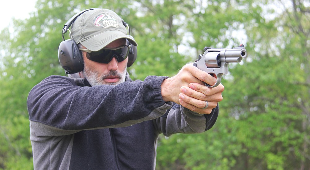 Male with fleece jacket shooting Smith & Wesson 69 Combat Magnum.