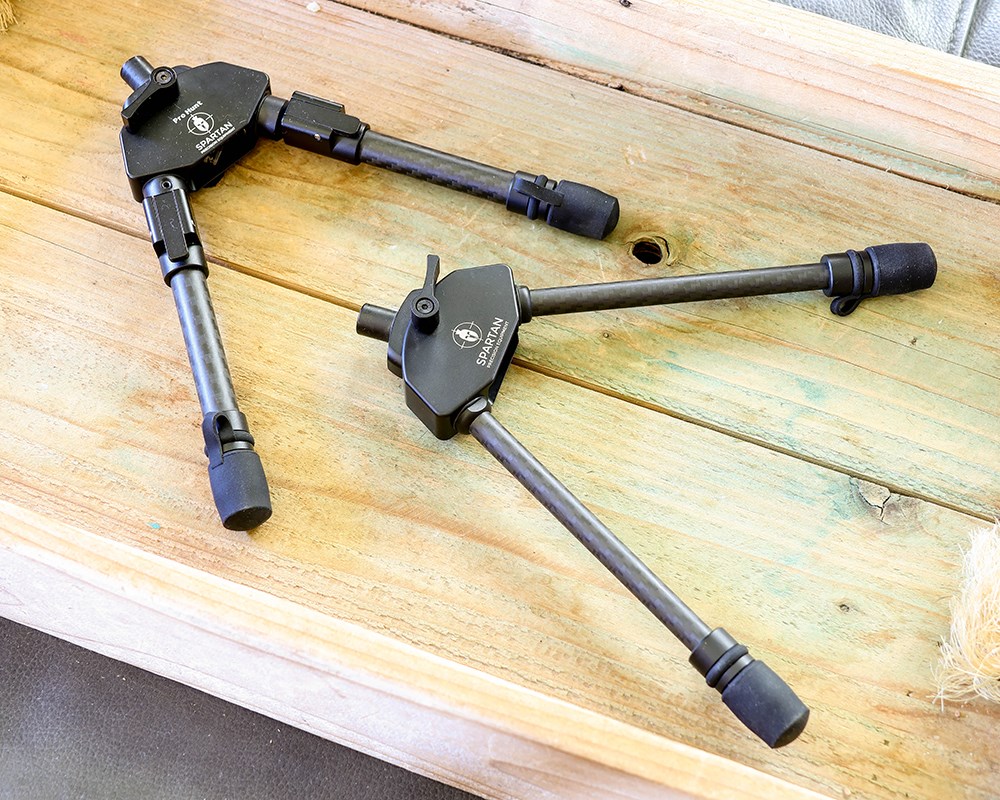 Two Spartan Precision Equipment bipods on wood table.