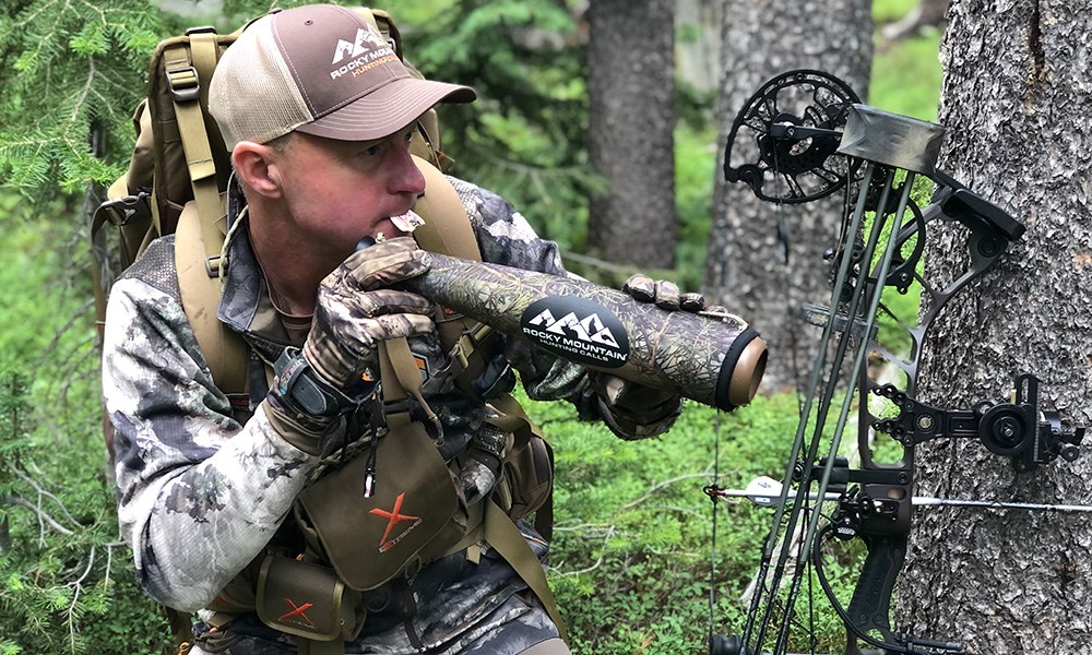Male Hunter using diaphragm call while bowhunting for elk.