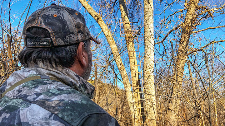 Hunter checking tree stand for maintenance.