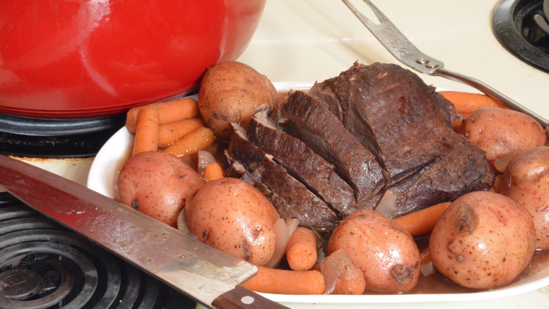 Meat and potatoes next to cast iron