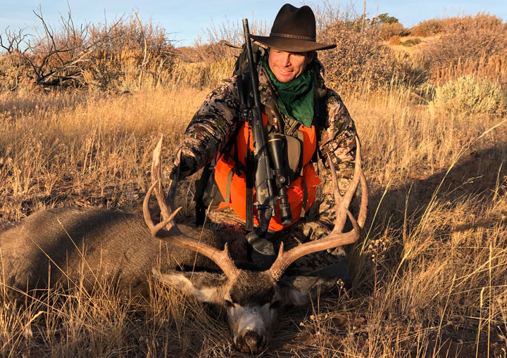 Hunter kneels over trophy buck