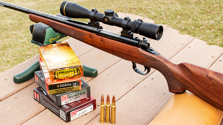 .338 Winchester Magnum Ammo with Rifle on Shooting Bench