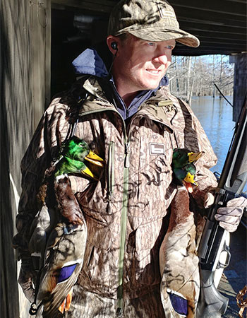 Hunter holding two mallard drakes