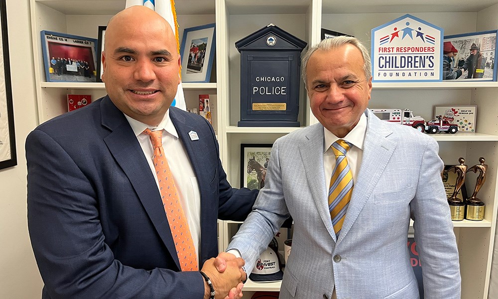 Two male adults shaking hands in office setting.