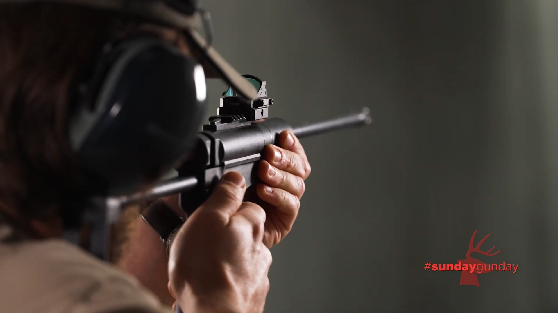 rear view of man shooting dark mountain arms stowaway rifle indoors