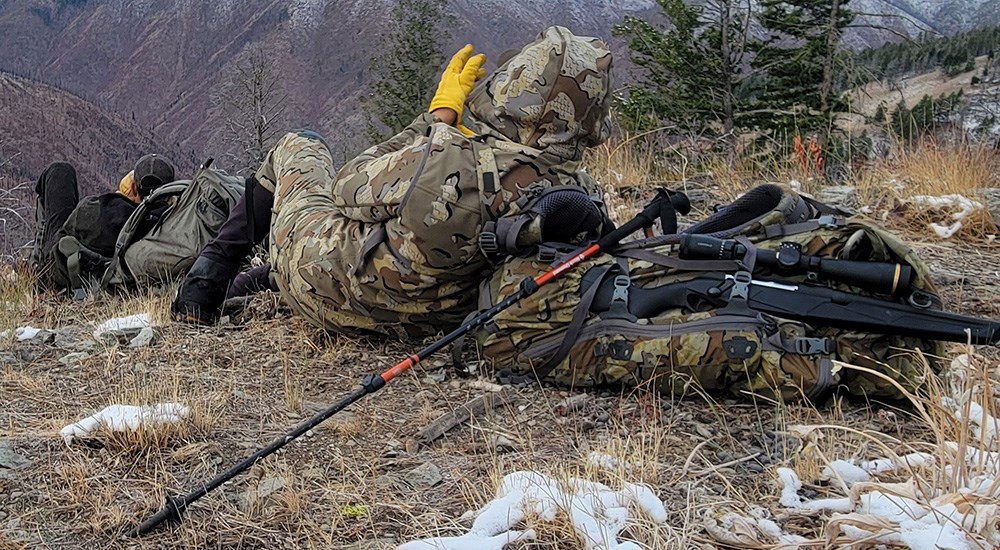 Hunter scanning mountain with binocular