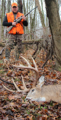 Hunter standing over a large whitetail buck