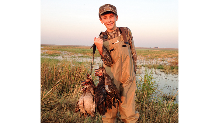 12-year-old hunter holding blue-winged teal taken in Texas