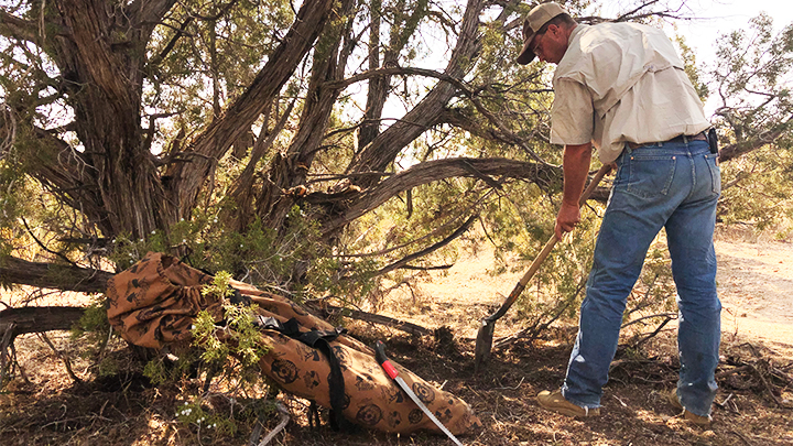 Hunter preparing area to set up ground blind for bow hunting