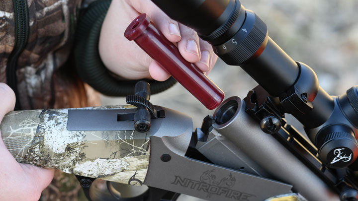 Federal Firestick being loaded into the breech of a camouflaged NitroFire muzzleloader.