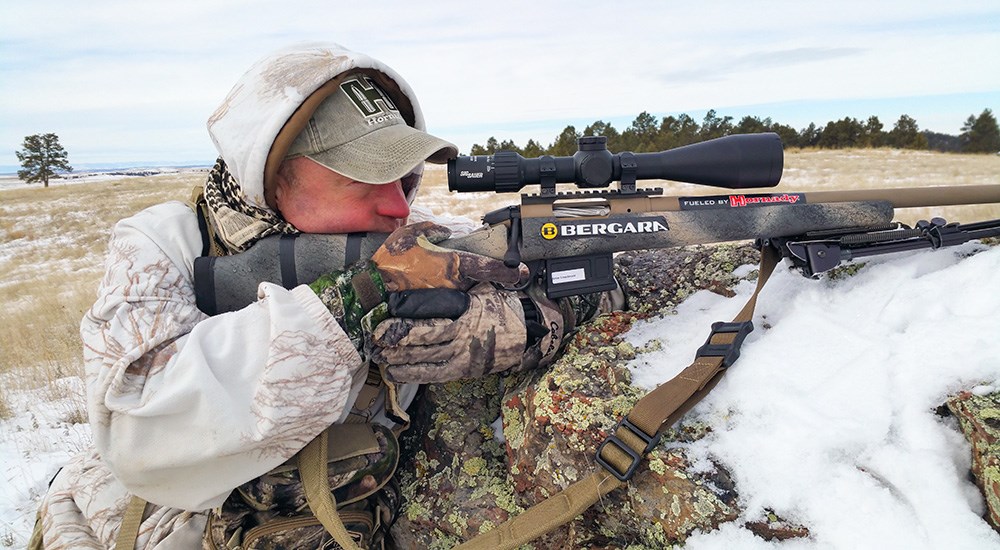 Male shooting Bergara bolt action hunting rifle on mountainside in winter.