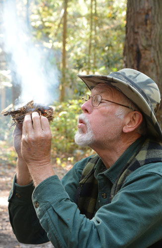 The author curls the nest and blows on it. White smoke rises from the top.