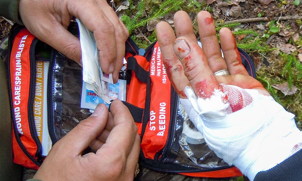 Using First Aid Kit to Dress Hand Wound in Wilderness