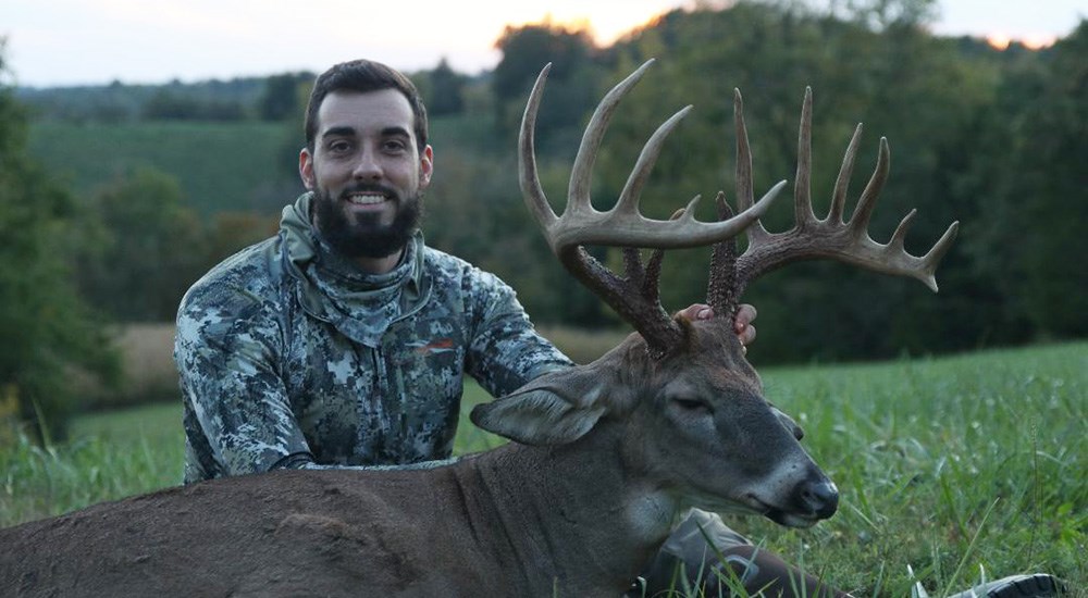 Male hunter holding up whitetail buck he killed in Montgomery County, Kentucky.